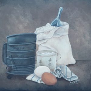 A bag of flour, measuring cup, sifter, eggs and a kitchen towel in the foreground surrounded by a rustic and textured background of browns and blacks.