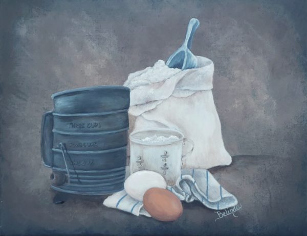 A bag of flour, measuring cup, sifter, eggs and a kitchen towel in the foreground surrounded by a rustic and textured background of browns and blacks.