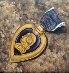 Purple heart medal laying in the foreground on a background of browns, blacks, and beiges that resembles army camouflage