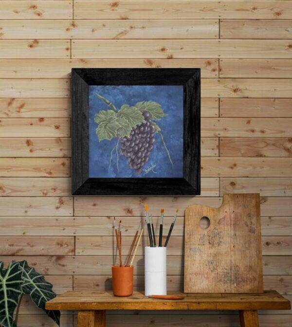 Painting of a lush grape cluster with green leaves against a deep blue background by artist Belinda Buckler