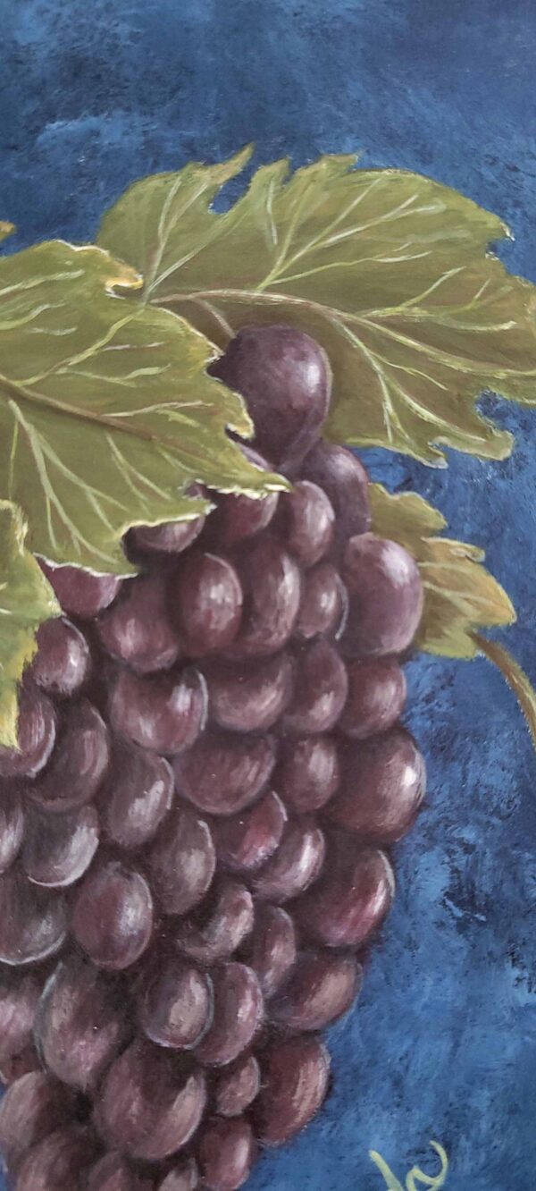 Painting of a lush grape cluster with green leaves against a deep blue background by artist Belinda Buckler